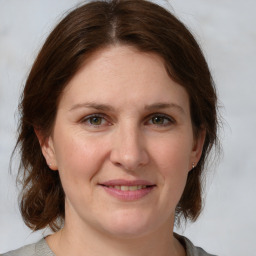 Joyful white adult female with medium  brown hair and grey eyes