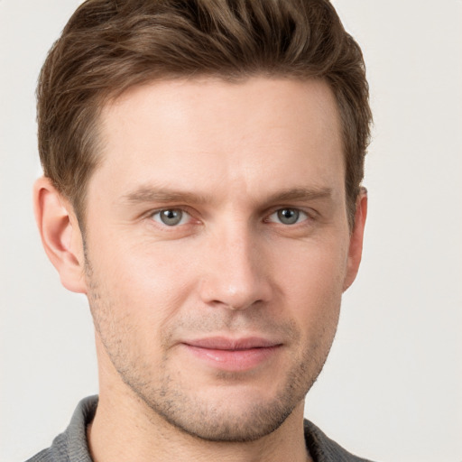 Joyful white young-adult male with short  brown hair and grey eyes