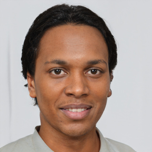 Joyful black young-adult male with short  brown hair and brown eyes