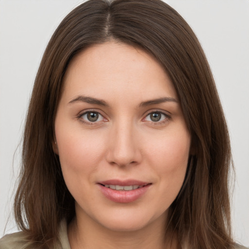 Joyful white young-adult female with long  brown hair and brown eyes