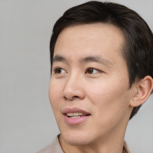 Joyful white adult male with short  black hair and brown eyes