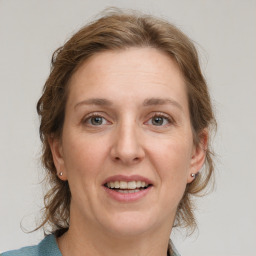 Joyful white adult female with medium  brown hair and grey eyes