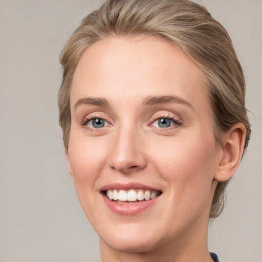 Joyful white young-adult female with medium  brown hair and blue eyes