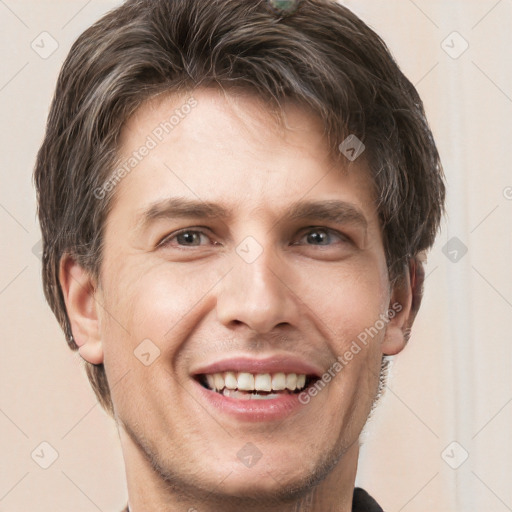 Joyful white young-adult male with short  brown hair and grey eyes