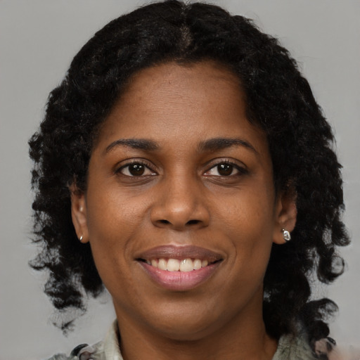 Joyful black young-adult female with short  brown hair and brown eyes