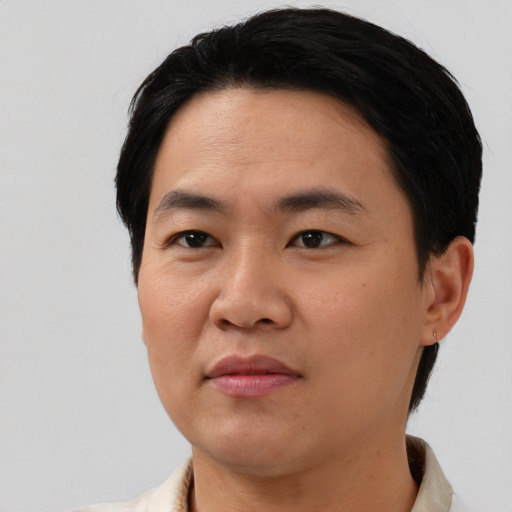 Joyful asian young-adult male with short  black hair and brown eyes