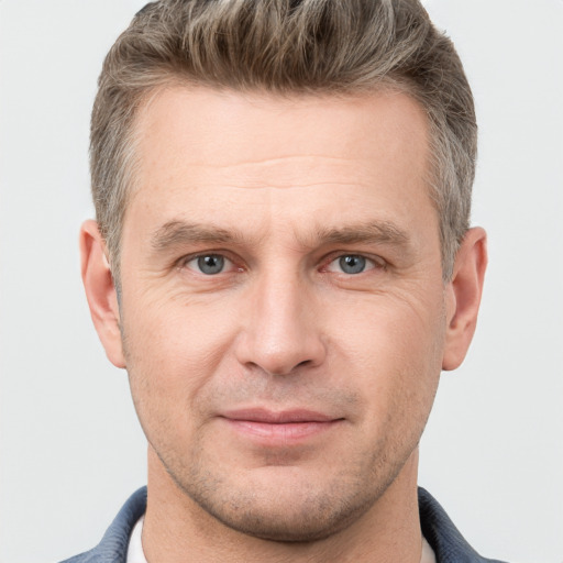 Joyful white adult male with short  brown hair and grey eyes