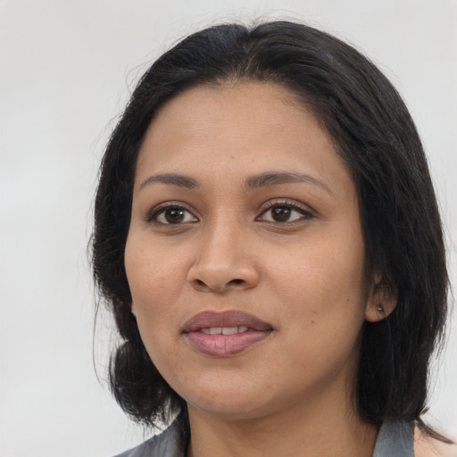 Joyful latino adult female with medium  brown hair and brown eyes