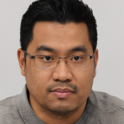 Joyful asian young-adult male with short  black hair and brown eyes