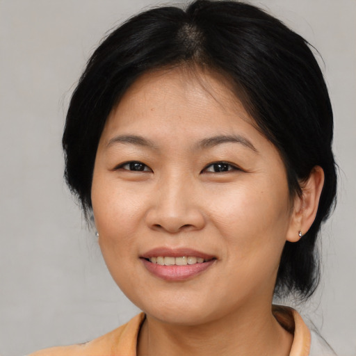 Joyful asian young-adult female with medium  brown hair and brown eyes