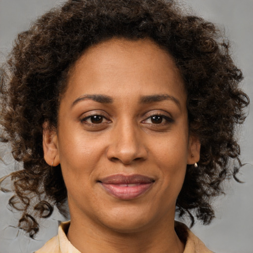 Joyful black young-adult female with medium  brown hair and brown eyes