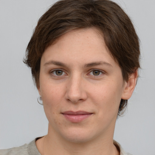 Joyful white young-adult female with short  brown hair and grey eyes