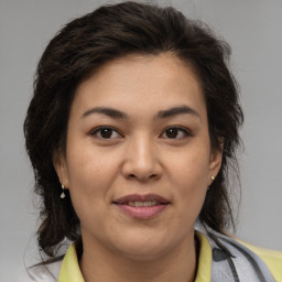 Joyful latino young-adult female with medium  brown hair and brown eyes