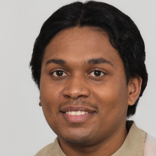 Joyful black young-adult male with short  black hair and brown eyes
