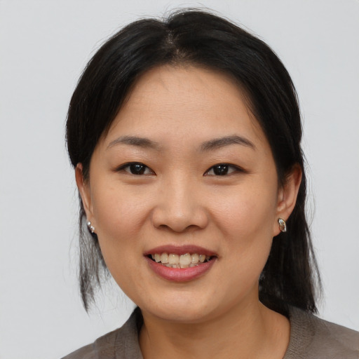 Joyful asian young-adult female with medium  brown hair and brown eyes