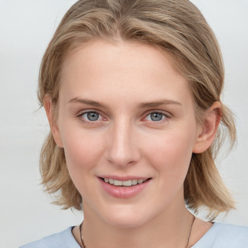 Joyful white young-adult female with medium  brown hair and blue eyes