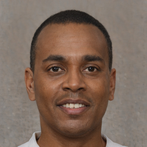 Joyful black young-adult male with short  black hair and brown eyes
