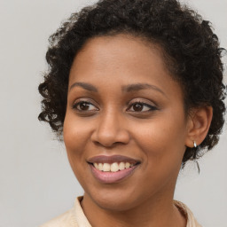 Joyful black young-adult female with long  brown hair and brown eyes