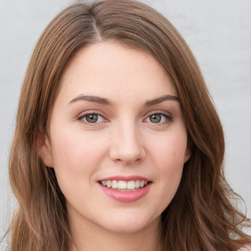 Joyful white young-adult female with long  brown hair and green eyes