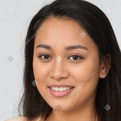 Joyful latino young-adult female with long  brown hair and brown eyes