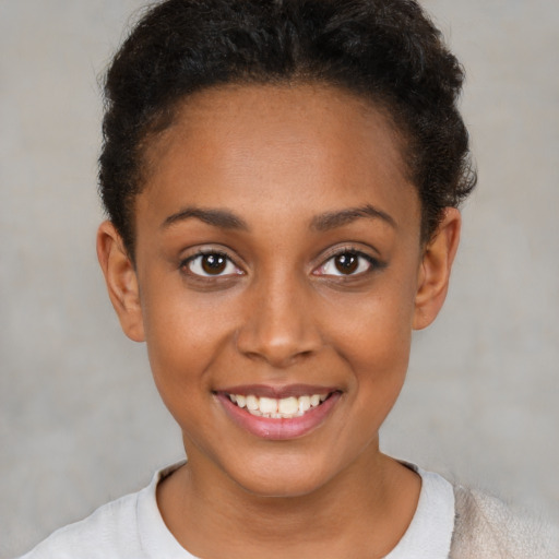 Joyful black young-adult female with short  brown hair and brown eyes