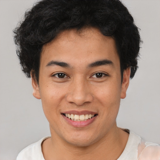 Joyful latino young-adult male with short  brown hair and brown eyes