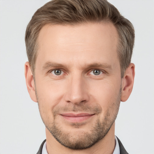 Joyful white young-adult male with short  brown hair and grey eyes