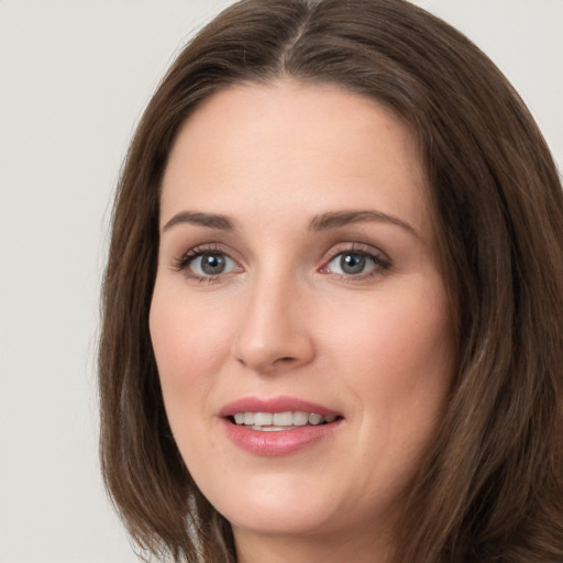 Joyful white young-adult female with long  brown hair and grey eyes