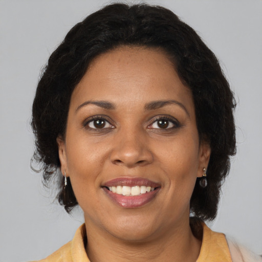 Joyful black adult female with medium  brown hair and brown eyes