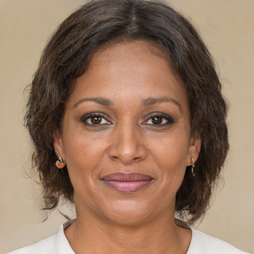 Joyful black adult female with medium  brown hair and brown eyes