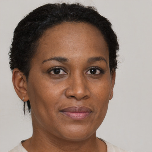 Joyful black adult female with short  brown hair and brown eyes