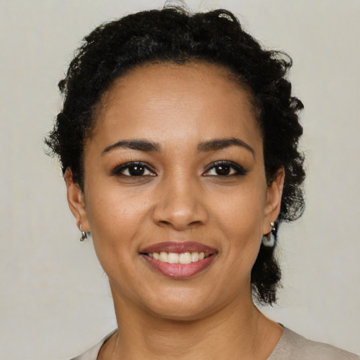 Joyful latino young-adult female with short  black hair and brown eyes