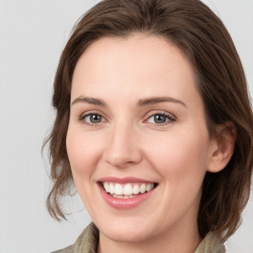 Joyful white young-adult female with medium  brown hair and grey eyes