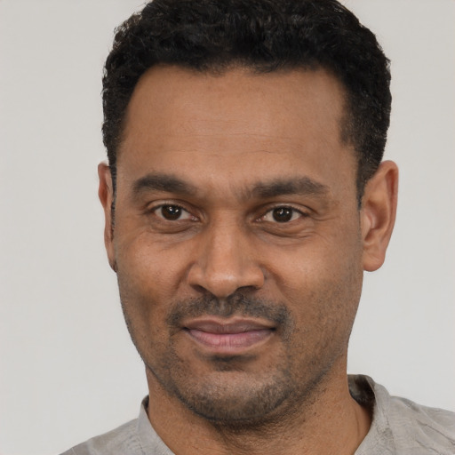 Joyful latino adult male with short  black hair and brown eyes