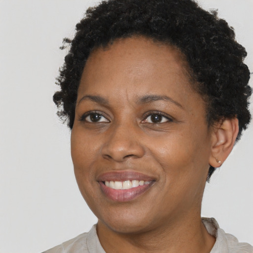 Joyful black young-adult female with short  brown hair and brown eyes