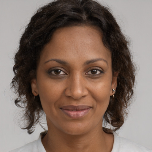 Joyful black young-adult female with medium  brown hair and brown eyes