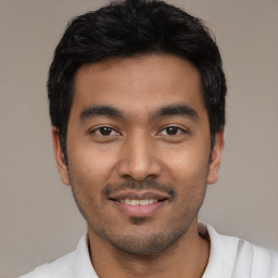 Joyful latino young-adult male with short  black hair and brown eyes