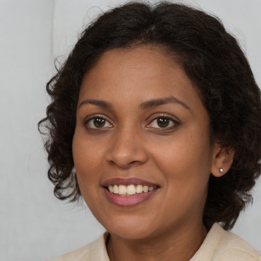 Joyful black young-adult female with medium  brown hair and brown eyes