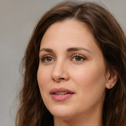 Joyful white young-adult female with long  brown hair and green eyes