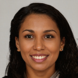 Joyful latino young-adult female with long  brown hair and brown eyes