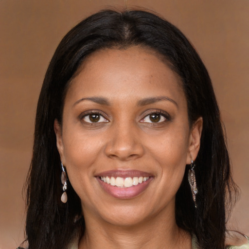 Joyful black young-adult female with long  brown hair and brown eyes