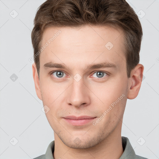 Joyful white young-adult male with short  brown hair and grey eyes