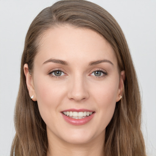 Joyful white young-adult female with long  brown hair and grey eyes