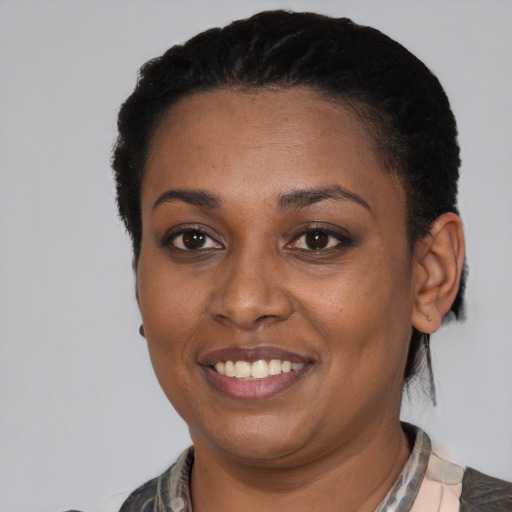 Joyful black young-adult female with short  black hair and brown eyes