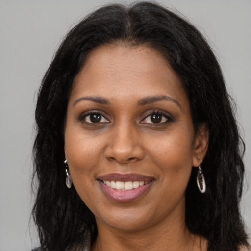 Joyful black young-adult female with long  brown hair and brown eyes