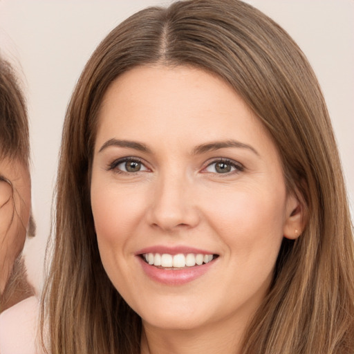 Joyful white young-adult female with long  brown hair and brown eyes