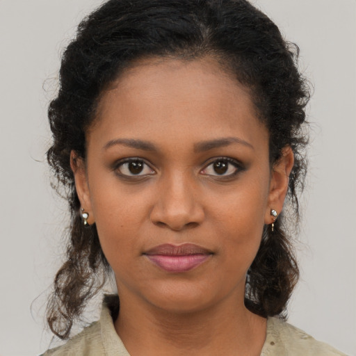Joyful black young-adult female with long  brown hair and brown eyes