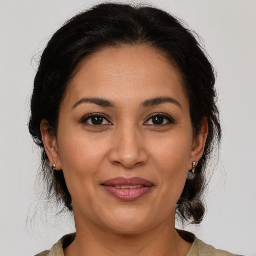 Joyful latino adult female with medium  brown hair and brown eyes