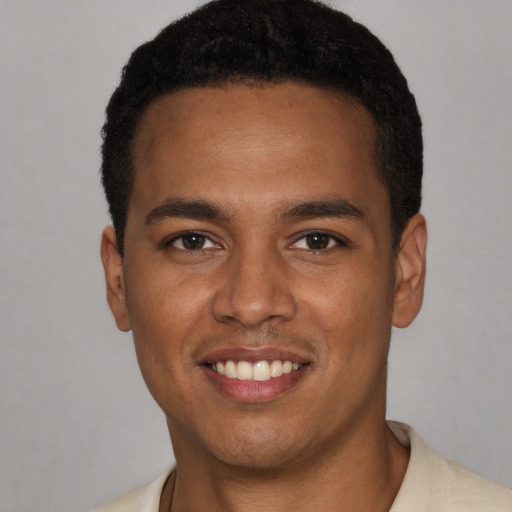 Joyful black young-adult male with short  brown hair and brown eyes
