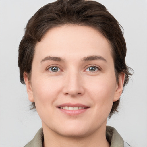 Joyful white young-adult female with medium  brown hair and grey eyes